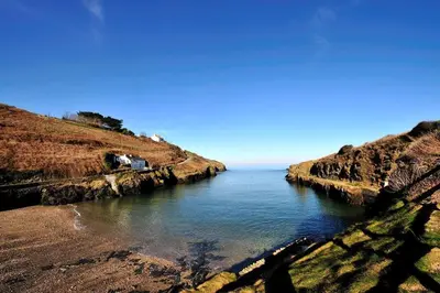 a view of a body of water between two hills at Port Gaverne Hotel in Port Isaac