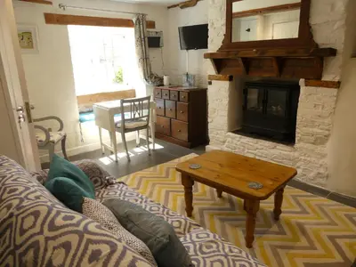a living room with a couch and a fireplace at Priory Cottage Bodmin in Bodmin