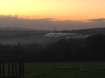 a view of a field with a sunset in the background at Priory Cottage Bodmin in Bodmin