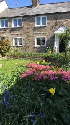 a brick house with flowers in front of it at Priory Cottage Bodmin in Bodmin