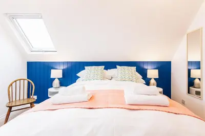 a bedroom with a large bed with blue walls at No4 St Ives in St Ives