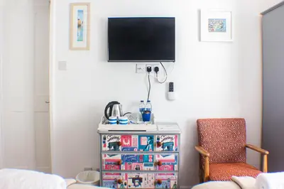 a living room with a tv and a chair at No4 St Ives in St Ives
