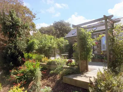 a garden in front of a small house at Lambriggan Court in Perranzabuloe
