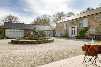 a home with a fountain in front of a building at Lambriggan Court in Perranzabuloe