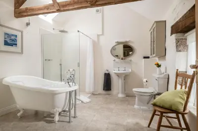 a bathroom with a tub and a sink and a toilet at Lambriggan Court in Perranzabuloe