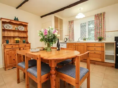 a kitchen with a wooden table and chairs at Miller's House in Tintagel
