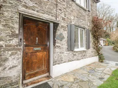 a wooden door on the side of a brick building at Miller's House in Tintagel