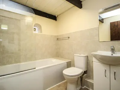 a bathroom with a toilet and a sink and a bath tub at Coachman's in Forrabury
