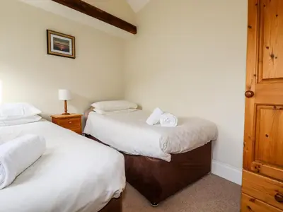 a bedroom with two beds with white sheets at Wheal Kitty in Newlyn East