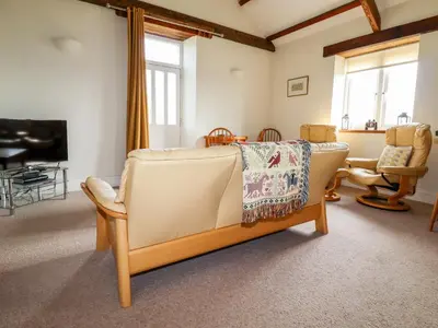 a living room with a couch and a chair at Wheal Kitty in Newlyn East