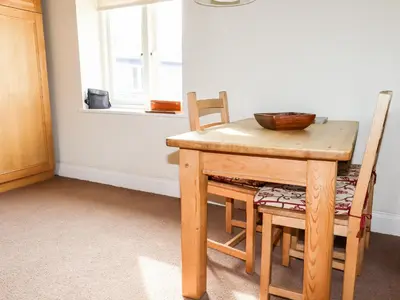 a wooden table with two chairs and a bowl on it at Wheal Rose in Newlyn East