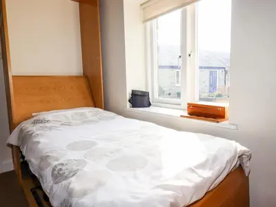 a bed in a room with a window at Wheal Rose in Newlyn East