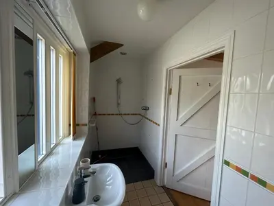 a bathroom with a white sink and a door at Wheal Hart in Newlyn East