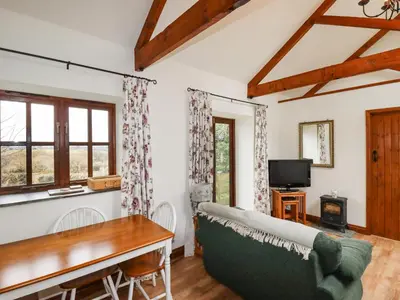 a living room with a couch and a table at Brocks Barn in Lanlivery