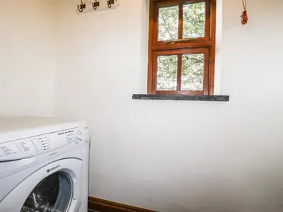 a washing machine in a room with a window at Brocks Barn in Lanlivery