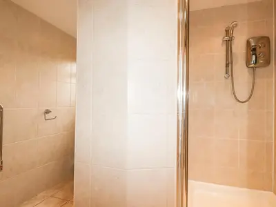 a shower with a glass door in a bathroom at Brocks Barn in Lanlivery