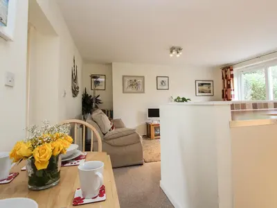 a kitchen and a living room with a table at An Kres in Mevagissey