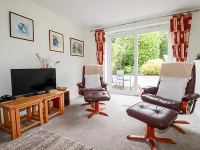 a living room with two chairs and a flat screen tv at An Kres in Mevagissey