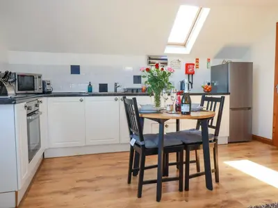 a kitchen with a table and chairs and a kitchen with a refrigerator at Sunnyvale in Bugle