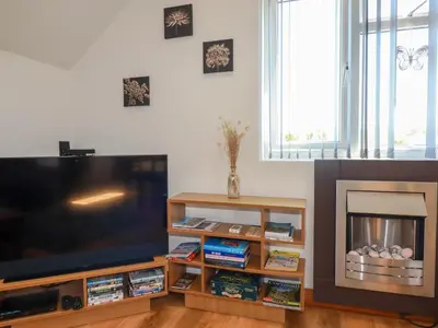 a living room with a flat screen tv and a fireplace at Sunnyvale in Bugle