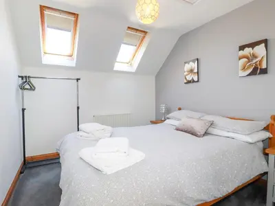 a bedroom with a bed with white sheets and windows at Sunnyvale in Bugle
