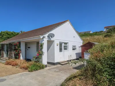 a small white house on the side of a hill at The Shack in Mawgan Porth
