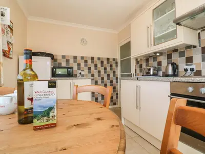 a bottle of wine sitting on a wooden table in a kitchen at The Shack in Mawgan Porth