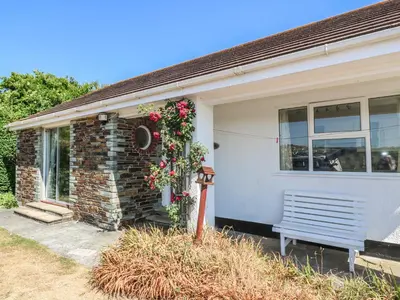 a house with a bench in front of it at The Shack in Mawgan Porth