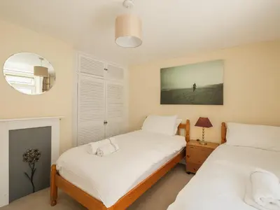 a bedroom with two beds and a mirror at 5 Bodmin Hill in Lostwithiel