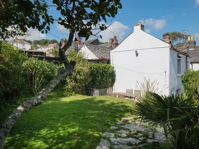 a white building in a yard with a tree at 5 Bodmin Hill in Lostwithiel