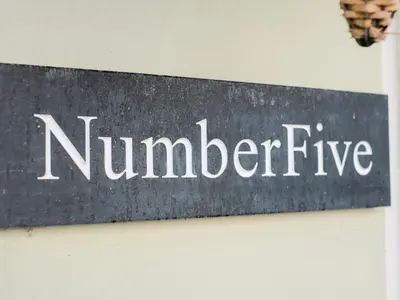 a sign that reads number five on a wall at 5 Bodmin Hill in Lostwithiel