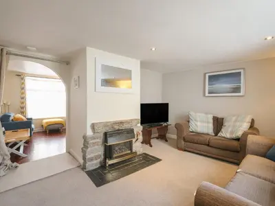a living room with a fireplace and a tv at 5 Bodmin Hill in Lostwithiel