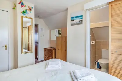 a bedroom with a white bed and a bathroom at Yazumez in Bugle