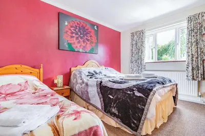 a bedroom with two beds and a pink wall at Yazumez in Bugle