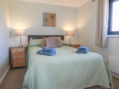 a bedroom with a bed with two towels on it at The Station Flat in Newlyn East
