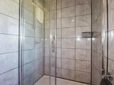 a bathroom with a shower with a glass door at The Station Flat in Newlyn East