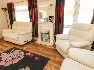 a living room with two chairs and a fireplace at 3 Rosecraddoc Lodge in Saint Cleer