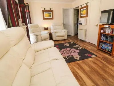 a living room with a white couch and two chairs at 3 Rosecraddoc Lodge in Saint Cleer