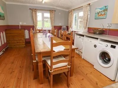 a dining room with a table and a washing machine at Trelydarth in St. Agnes
