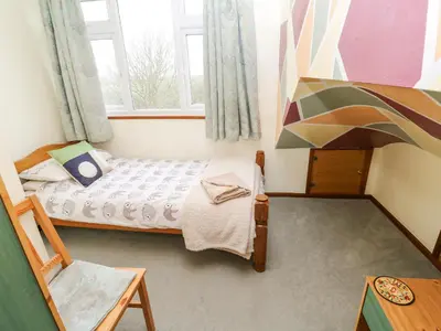 a small bedroom with a bed and a window at Trelydarth in St. Agnes