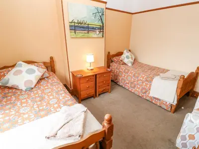 a small room with two beds and a night stand at Trelydarth in St. Agnes