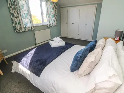a bedroom with a large bed with pillows on it at Two Threes in Saint Hilary