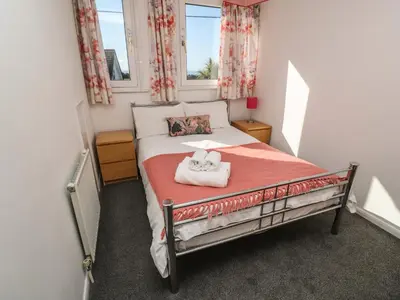 a small bedroom with a bed with two towels on it at Two Threes in Saint Hilary