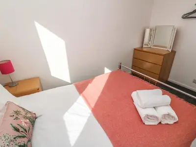a bedroom with a bed with two towels on it at Two Threes in Saint Hilary