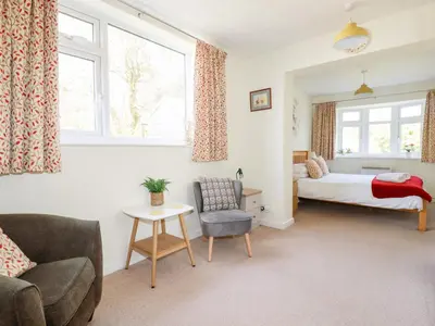 a bedroom with a bed and a couch and a chair at Harlyn in Mevagissey