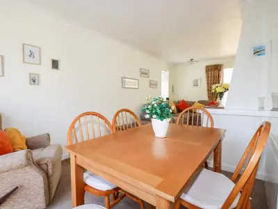 a dining room with a wooden table and chairs at Harlyn in Mevagissey