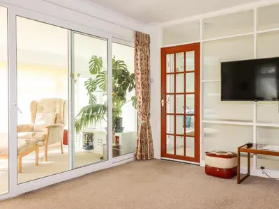 a living room with a sliding glass door at Harlyn in Mevagissey