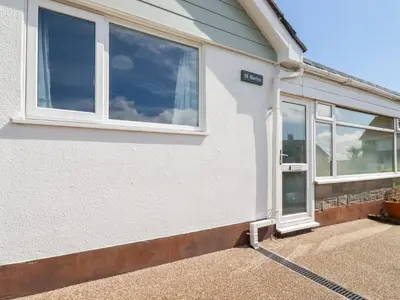 a white house with windows and a driveway at Harlyn in Mevagissey