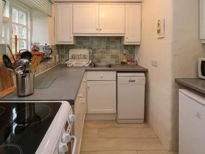 a kitchen with white cabinets and a sink at Honeycrock in Cubert