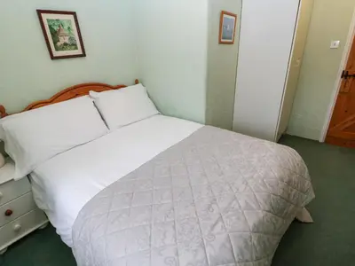 a bedroom with a large white bed in a room at Honeycrock in Cubert